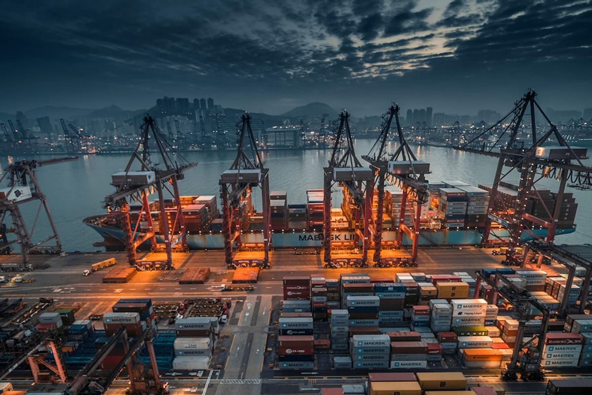 Container ship being loaded at port at dusk